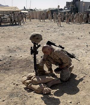 A U.S. Marine pays his respects to a fallen comrade, killed earlier this month in a Taliban ambush, during a memorial service Thursday at a forward operating base in Now Zad in Afghanistan's Helmand province.