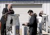 A man uses a gas pump as a desk during a job fair at New Hampshire Motor Speedway on Thursday in Loudon, N.H.