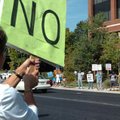 <b>Health care crowd</b>
Kim Brinson, left, holds a up a sign while standing along College Avenue w...