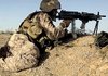 U.S. Marine Will Betz trains his machine gun Friday on Taliban forces after being shot at during a patrol in Helmand province, Afghanistan.