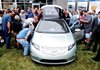 General Motors employees look over a 2011 Chevrolet Volt plug-in hybrid Friday at its powertrain plant in Bay City, Mich., after GM announced a $37 million investment to produce engine parts at the plant.