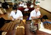 Odalis Fonseca (left) and Marta Diaz apply wrappers to cigars at a cigar factory in Miami's Little Havana neighborhood earlier this month.