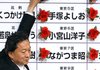 Yukio Hatoyama, president of the Democratic Party of Japan, places a red paper rose next to a Democratic candidate's name to indicate a victory at the party's election center Sunday in Tokyo.
