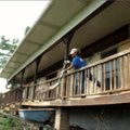 Habitat Recycling:  Denise Decker unloads a shovelful of debris into a wheelbarrow while working wit...