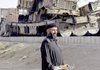 A Pakistani police officer stands next to burned trucks loaded with supplies for NATO forces fighting in Afghanistan after an explosion Monday in Chaman, Pakistan, near the Afghan border.