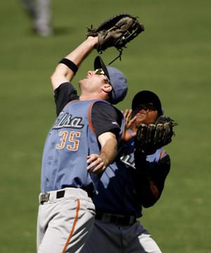 Tulsa first baseman Jeff Kindel (left) collides with second baseman Daniel Mayora before fielding a fly ball during the third inning of Sunday's game against Northwest Arkansas. 