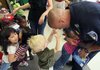 North Little Rock Patrolman Tommy Norman gets a hug from Brianna McKenzie and a poke above his eyes from Blaine Schooley as he greets them Monday at the Redwood Early Childhood Center in North Little Rock. 