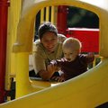 Cyndi McCrory of Rogers shows Gavin Grear, 1, how to start down a slide Monday morning at Lake Atala...