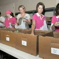 Members of the Junior Auxiliary of Bentonville-Rogers demonstrated how they pack the Snack Packs for...