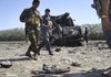 Policemen look at burnt rifles as they investigate one of two burnt fuel tankers near Kunduz, Afghanistan, on Friday, Sept. 4, 2009. 