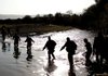 U.S. and German soldiers wade through knee-high water Saturday to inspect the NATO tankers destroyed by a U.S. bombing strike outside Kunduz, Afghanistan.