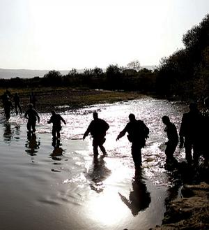U.S. and German soldiers wade through knee-high water Saturday to inspect the NATO tankers destroyed by a U.S. bombing strike outside Kunduz, Afghanistan.