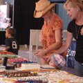 Tonia Squires, left, looks at some jewelry at Evelyn and Bill's Western Wear and More display with h...