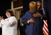 President Barack Obama hugs Nate Guyton, onstage with Linda Grual, after addressing the American Nurses Association on Thursday in the Eisenhower Executive Office Building at the White House complex.