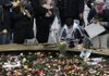 A man carries a photograph of a woman as he joins other mourners around a reflecting pool during a memorial ceremony at the World Trade Center construction site, Friday, Sept. 11, 2009 in New York.
