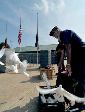 Gary Wellesley of Rogers Veterans of Foreign Wars Post 3031 released a basket of white doves during a 9/11 memorial ceremony at Veterans Park in Rogers on Friday morning.