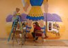 Sandy Bartholomew, left, and Gina Beeks work on the David and Goliath mural in the children's wing of the First United Methodist Church in Prairie Grove. A crew of volunteers worked on several murals in the children's wing and nursery of the church, which the congregation is moving into and will have its first service in Sunday.