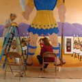 Sandy Bartholomew, left, and Gina Beeks work on the David and Goliath mural in the children's wing o...