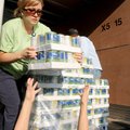 reached up to
receive a case
of canned
sweet peas
from Courtney
Guppy
from Mercy
Health Syste...