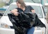 Carolyn Benham of Rogers hurried inside the Crafts Building with her artwork covered in plastic for checkin at the Benton County Fair on Monday. 
 