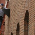 Bob Martin of Centerton repairs a light on the front of the Arvest Bank on Elm St. in Rogers Tuesday...