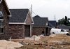 A worker stands near houses being built in July on Gunnison Avenue in the Parker Place subdivision in Springdale.