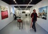 University of Arkansas at Fayetteville graduate student and Student Gallery Director Garry Holstein places labels on art pieces Wednesday. The new gallery is located at 114 Central Ave. in Bentonville.