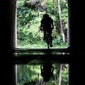 A cyclist is reflected in a puddle left over from the recent rain while passing through the tunnel u...