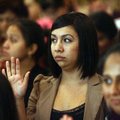 Patricia Carranza of Springdale, originally from Mexico, raises her right hand to take the Oath of A...