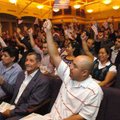 Rena Aleala, right, and about 70 other new American citizens wave flags in celebration Thursday at t...