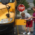 Tyler Davis, left, checks the battery on a school bus as driver Trisha Labit looks on during a safet...
