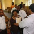 The Rev. Curtiss Smith, left, talks with Rainita Thompson and Henry Soil, right, after a dedication ...