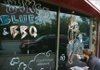 Joy Sagan, a server and artist with The Common Grounds, puts the final touches on a mural outside the longtime restaurant and bar in preparation for Bikes, Blues & BBQ.