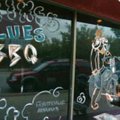 Joy Sagan, a server and artist with The Common Grounds, puts the final touches on a mural outside th...