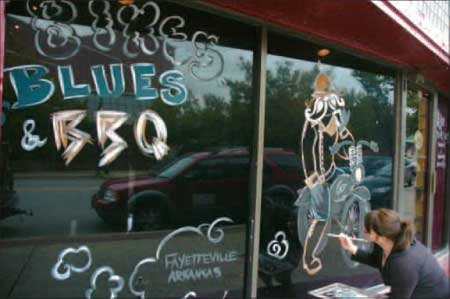 
                               
                                  Photo by Anthony Reyes&mdash;
                               
                           
                           Joy Sagan, a server and artist with The Common Grounds, puts the final touches on a mural outside the longtime restaurant and bar in preparation for Bikes, Blues & BBQ.