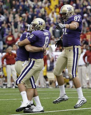 Washington kicker Erik Folk and holder Ronnie Fouch celebrate with teammate Romeo Savant after defeating Southern California on Saturday. The victory propelled Washington into the AP Top 25 for the first time since 2003. The Huskies are ranked No. 24.