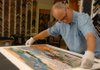J.D. White, co-owner of Frameworks, works on framing a piece using a float mount at his workshop Thursday in Fayetteville. 