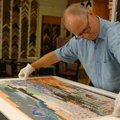 J.D. White, co-owner of Frameworks, works on framing a piece using a float mount at his workshop Thu...