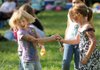 Jaden Jackson, 7, left, laughs as friend, Natalie Ricarte, 8, both of Mountainburg, sprays her with aerosol string while playing Sunday during the 27th annual Winfest at the Winslow ball fields.