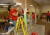 Volunteer Daisy Nelson paints some arches Friday in the library at Asbell Elementary School in Fayetteville. Nelson joined dozens of other Target employees at the school to give the library a $3,000 makeover. 