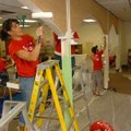 Volunteer Daisy Nelson paints some arches Friday in the library at Asbell Elementary School in Fayet...