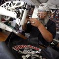 "Stitcher Gene" loads thread into his sewing machine Wednesday inside his booth along Dickson Street...