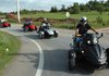 Larry Sherwin, right, tests out a Spyder roadster by Can-Am on Wednesday on Cato Springs Road in Greenland during the opening day of Bikes, Blues & BBQ. Patrons can sign up for a demo ride at the Bradford Marine and ATV tent in the Randal Tyson Track Center lot in Fayetteville. 