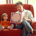 Blue Berenguel, age 2, sits with her father Justin Berenguel, of Fayetteville, as he reads her a sto...