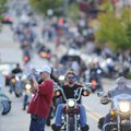 Eric Wadsworth, of Siloam Springs, photographs a motorcycle as a line of motorcyclists pass along We...