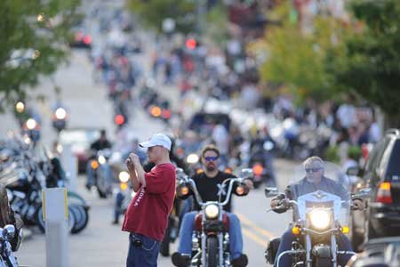 
                               
                                  Photo by Andy Shupe&mdash;
                               
                           
                           Eric Wadsworth, of Siloam Springs, photographs a motorcycle as a line of motorcyclists pass along West Dickson Street on Thursday in Fayetteville as the 10th annual Bikes, Blues & BBQ motorcycle rally begins to build up steam. The rally runs through Saturday. 