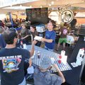 Don Bennett, a friend of the owner of Lucky Luke's BBQ, center, hands a sample rib to H.P. Wright, o...