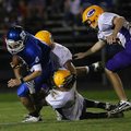 Bryant's Logan Garland (4) is brought down by Little Rock Catholic defenders in the first quarter of...