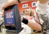Sage Sanger of Intralot Inc. installs a lottery ticket checker Friday at the Sufficient Grounds Metro eatery in downtown Little Rock.