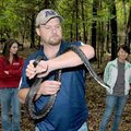 College biology professor David Jamieson held a large rat snake that he found in his trap at the Pea...